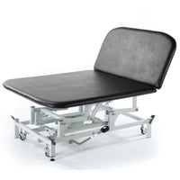 Dark grey hydraulic Bobath therapy couch with wheels, for medical or physiotherapy, side view.
