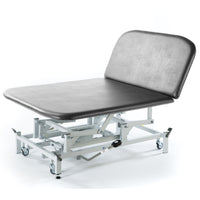 Light grey hydraulic therapy Bobath couch with padded top, metal frame, and wheels for easy movement, side view.