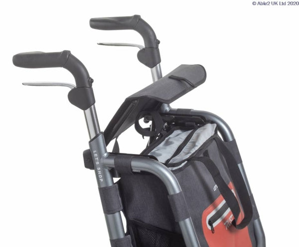 Handles and upper frame of the Trust Care Let’s Shop Rollator in black with attached shopping bag, close-up view.