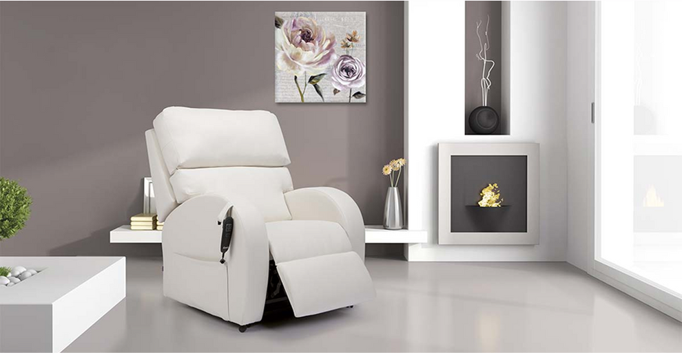 Modern living room featuring an elegant white riser recliner chair with a handheld control, positioned beside a minimalist fireplace and floral wall art, highlighting a stylish and functional seating solution.