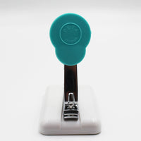 Easi-Grip table-top finger nail clipper with circular top, white base and non-slip feet, front view.