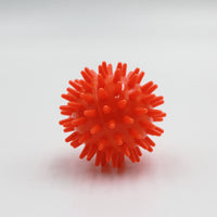 Homecraft massage ball with spikes for muscle tension relief, plain white background, front view.