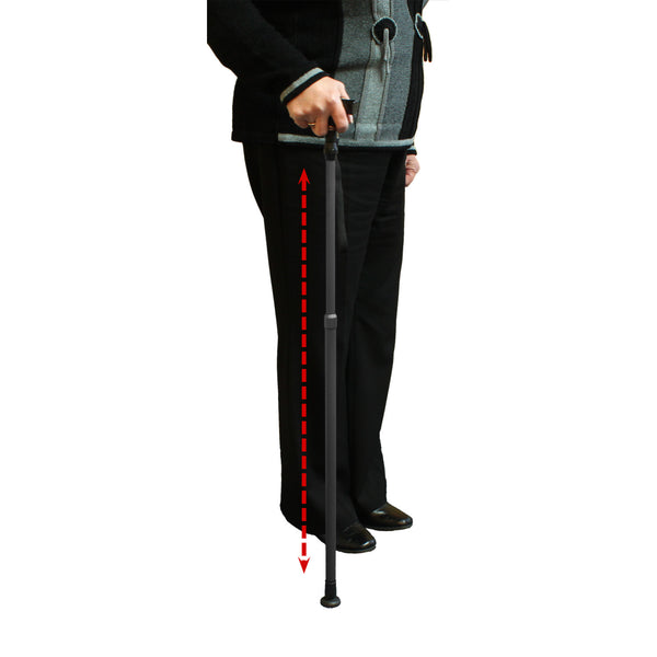 Person holding Lifemax Adjustable Walking Stick with dashed arrow highlighting non-slip rubber foot touching the floor, in use view.