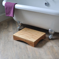Gordon Ellis Bamberry Bath Step on bathroom floor in front of white clawfoot tub with towel on edge, front view.