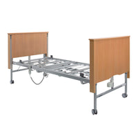 Sidhil Bradshaw Nursing Care Bed with metal frame, wooden ends, wheels, shown without mattress, front view.