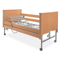 Sidhil Bradshaw Nursing Care Bed with wooden headboard, metal frame and wheels, designed for nursing care needs, front view.