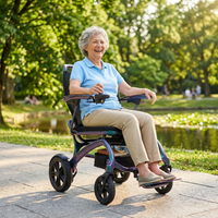 Elderly woman using Wizemed C100 Carbon Fibre Folding Powerchair outdoors by a pond and trees, in use.