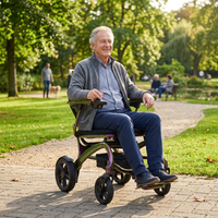 Man riding a Wizemed C100 Carbon Fibre Folding Powerchair in a sunny park, trees and pond in background, in use.