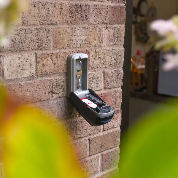 Supra C500 Pro police approved keysafe open with keys inside, mounted on a brick wall, front view.