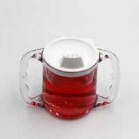 Homecraft Caring Mug with clear plastic body, angled handles, white spout lid and red liquid, on white background, front view.