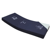 Harvest Healthcare Community Plus Static Mattress with exposed white foam for hospital use, angled side view.