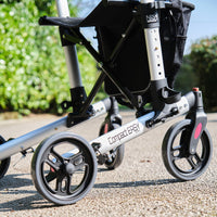 NRS Compact Easy Rollator wheels and frame for walking support outdoors, close-up view.