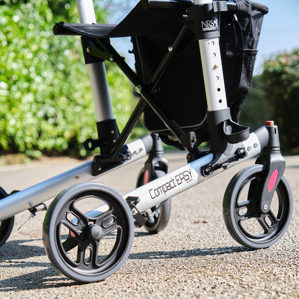 NRS Compact Easy Rollator wheels and frame for walking support outdoors, close-up view.