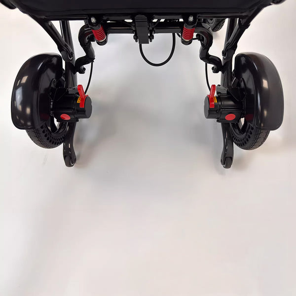 Dash Rehab Dash Carbon Max HD Power Chair underside with two rear wheels and red locking mechanisms, close-up view.