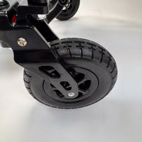 Treaded wheel on metal frame of Dash Rehab Dash Carbon Max HD Power Chair, close-up.