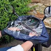 Hands using a delta tiller scooter fitted with an Able2 Delta Scooter Control Panel Cover protecting dashboard from weather, in use view.