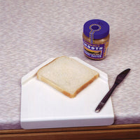 Gordon Ellis Derby Preparation Board with non-slip base for one-handed food preparation, shown spreading on bread, in use view.