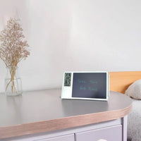 Lifemax Digital Memo Board and Day Date Clock displaying Take two red pills beside dried flowers in a vase, front view.