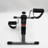 Digital pedal exerciser with resistance dial, foot straps and digital screen, shown from a side angle.