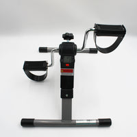 Digital pedal exerciser with resistance dial, foot straps and digital screen, shown from a side angle.