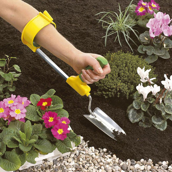 Easi-Grip Arm Support Cuff shown on gardener’s arm while digging soil, supports grip strength, in use.