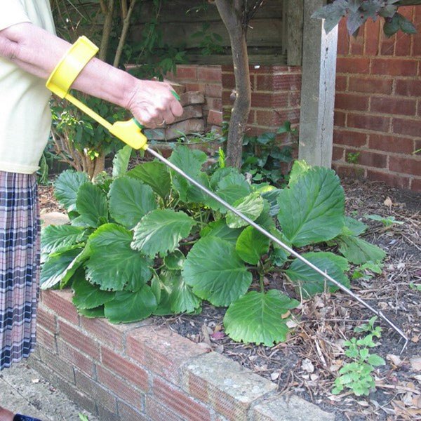 Easi-Grip Arm Support Cuff helping a person with arthritis tend to plants in a garden bed, in use.