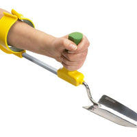 Hand holding an Easi-Grip Arm Support Cuff for gardening, showing ergonomic handle, in use view.