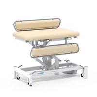 Medi-Plinth electric changing table with padding, metal rails, and wheeled base for wheelchair access, side view.