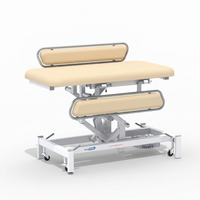 Medi-Plinth electric changing table with padded surface, metal frame and wheels, suitable for easy transfers, side view.