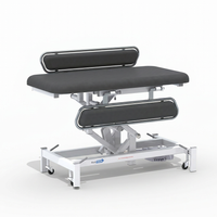 Medi-Plinth Electric Changing Table with MRSA-resistant upholstery, metal frame, safety rails and wheels, side view.