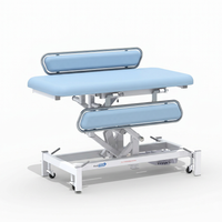 Medi-Plinth electric changing table with wheels, metal railings and MRSA-resistant upholstery, side view.