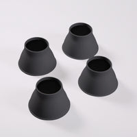 Four Gordon Ellis Elephant Feet bed & chair raisers arranged on a white surface, used for raising furniture, top view.