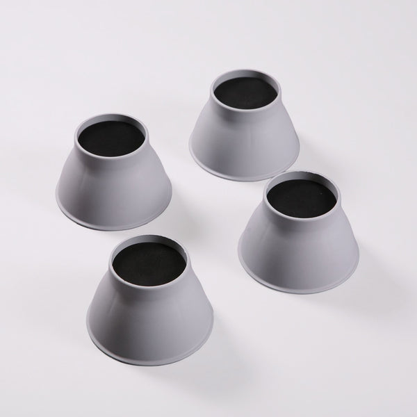 Four Gordon Ellis Elephant Feet bed and chair raisers with black tops, shown on a white surface, top view.