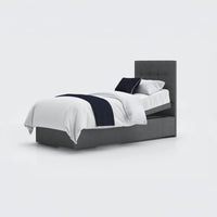 Opera Beds Emerald Motion Adjustable Divan Bed with white bedding, navy throw and pillow on plain white background, front view.