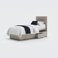 Emerald Motion Adjustable Divan Bed with tufted headboard, white bedding, navy accents, two storage drawers, side view.