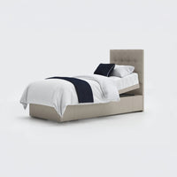 Emerald Motion adjustable divan bed by Opera Beds, upholstered frame, white bedding, navy throw and pillow, front view.