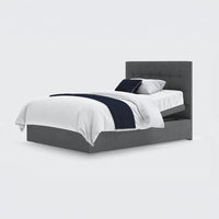 Opera Beds Emerald Motion Adjustable Divan Bed with tufted headboard, white bedding and dark blue accents, front view.