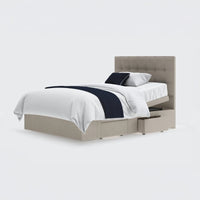 Emerald Motion Adjustable Divan Bed with white bedding, navy throw, pillows and two open drawers, side view.