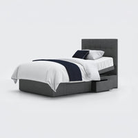 Opera Beds Emerald Motion Adjustable Divan Bed with white bedding, navy throw, two pillows and open storage drawers, front view.