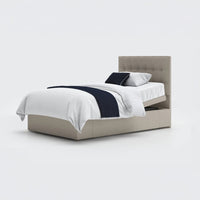 Opera Beds Emerald Motion Adjustable Divan Bed with white bedding and dark blue throw, plain background, front view.