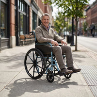 Man using Days Escape Lite Self Propel Wheelchair outdoors on a city pavement near shopfronts, in use view.