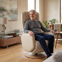 Older man sitting in a Fitzroy Riser Recliner by Modern Motion in a bright living room with wooden floors, in use view.