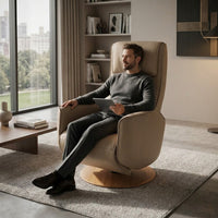 Man sitting in a Modern Motion Fitzroy Riser Recliner Swivel Chair using a tablet in a modern living room, front view.