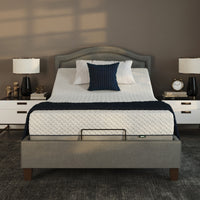 Opera Beds Flyte Adjustable Bed with white bedding, bedside tables, lamps and decor in a modern bedroom, front view.
