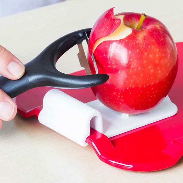 Hand using ORNAMIN Food Preparation Aid to cut food on a chopping board, in use view.