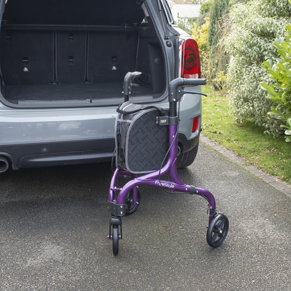 NRS Freestyle 3 Wheel Rollator with black bag next to open SUV boot on driveway near plants, side view.