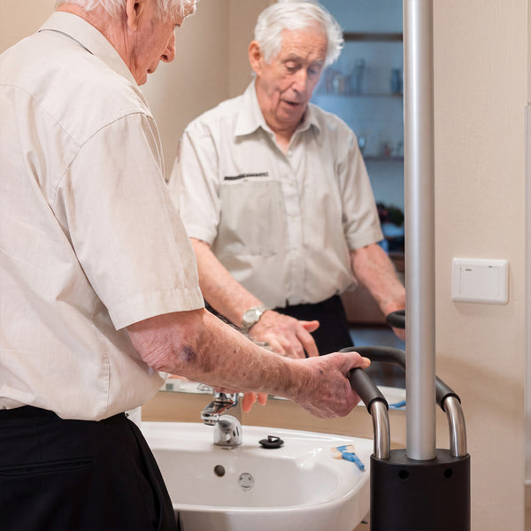 GRIPO Multi Grip Support Handle in use by elderly man for balance at bathroom sink and mirror, in use view.