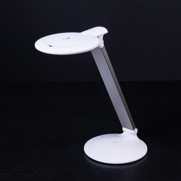 The Daylight Company Halo Go 2 Magnifying Lamp with circular base, rechargeable and adjustable arm on black background, front view.