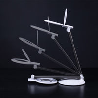 Daylight Company Halo Go 2 Magnifying Lamp with adjustable arm and flexible head, shown from multiple angles, dark background.