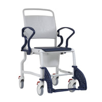 White and navy mobile commode chair with armrests, adjustable footrests, padded seat and removable bucket, front angle view.